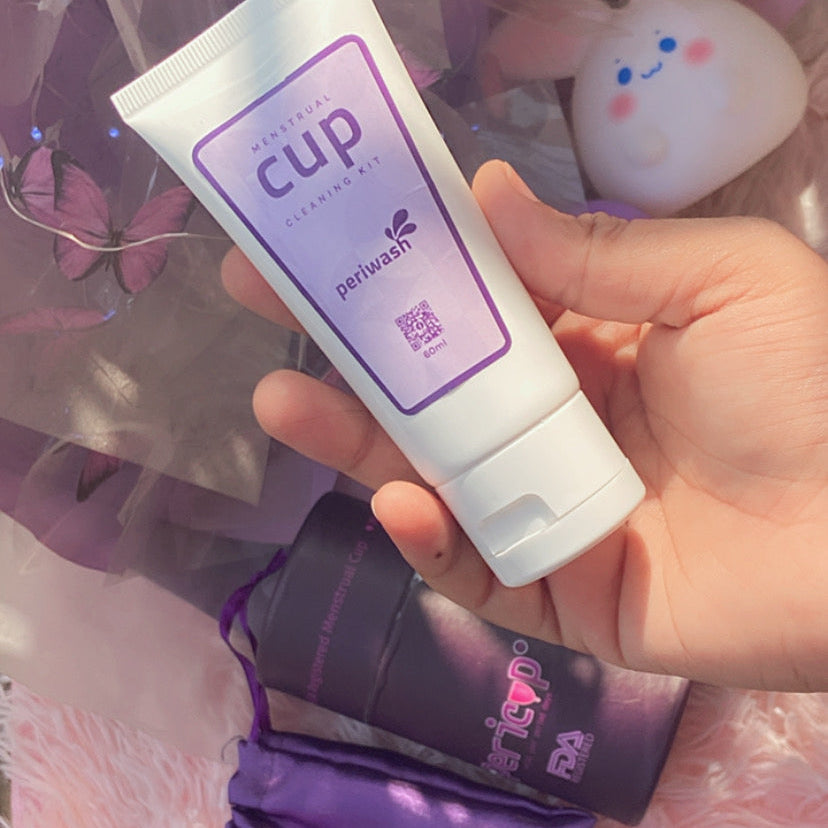 Hand holding a white tube labeled 'cup' against a colorful background with plush toys.